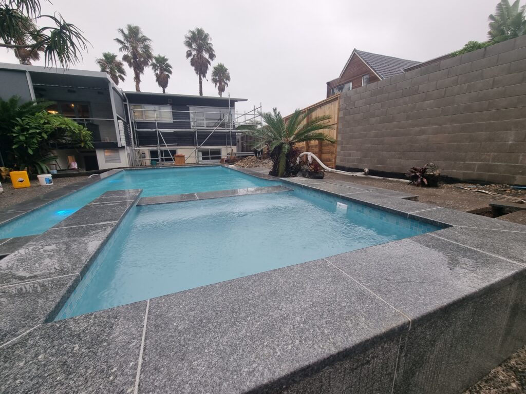 Large-format pavers laid around a renovated pool, Birkenhead