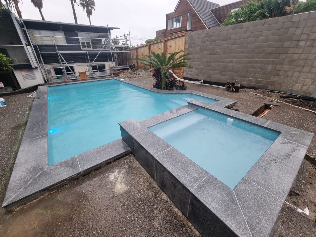 Pool renovation in Birkenhead Auckland with infinity edge spa and granite coping