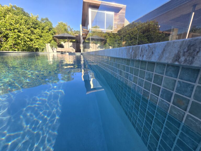 Pool with stone coping and planted surround, Westmere