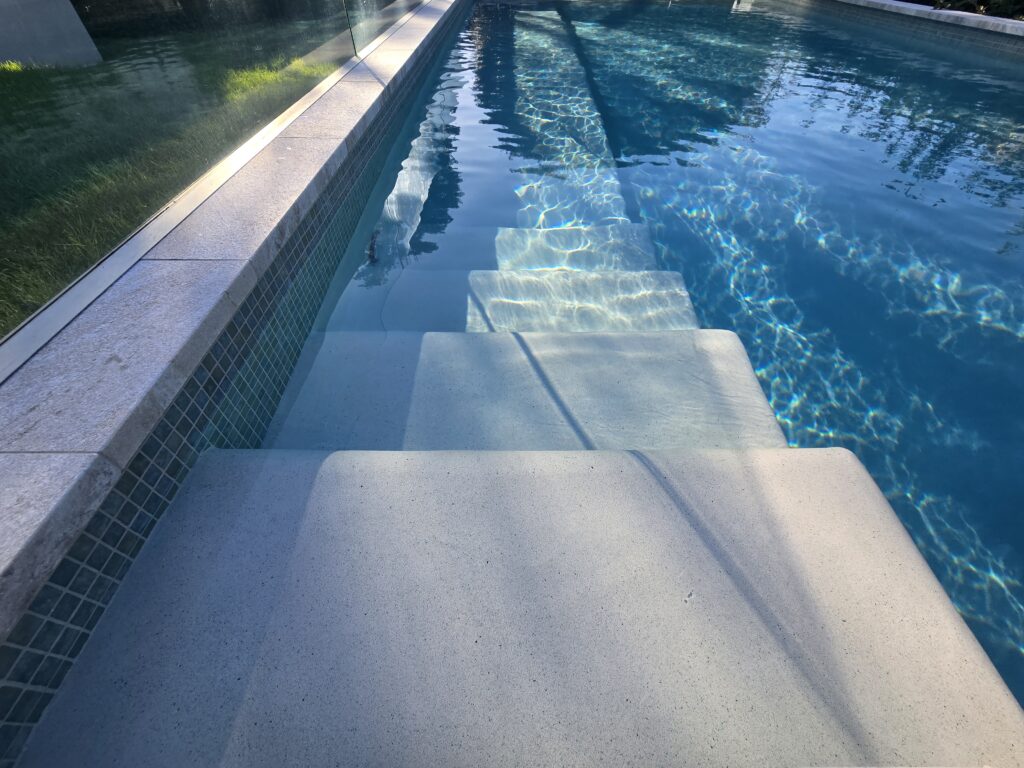 Renovated Westmere pool with glass mosaic tiling and stone coping, Auckland