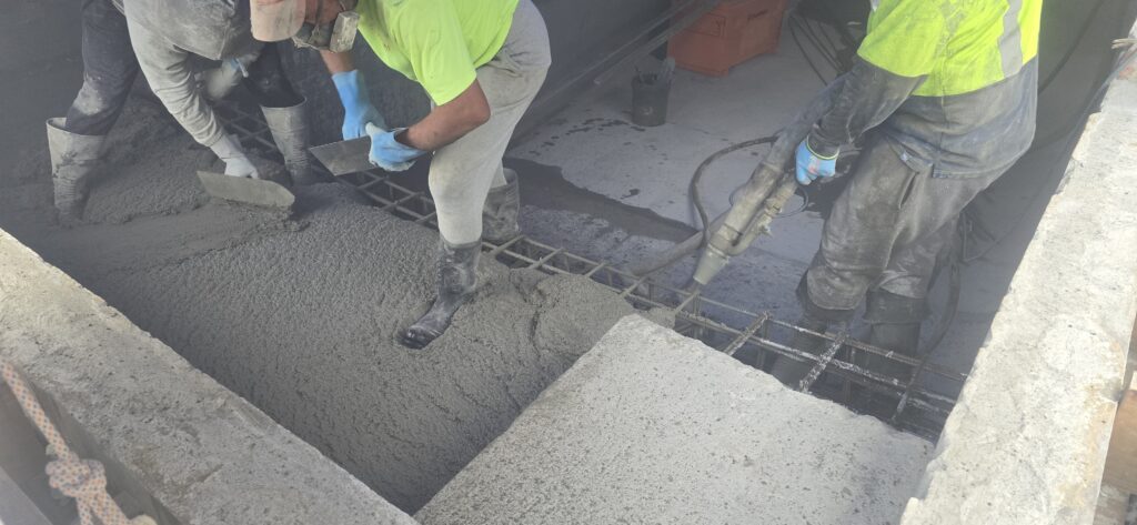 Concrete being placed over steel reinforcement during a concrete pool build in Auckland