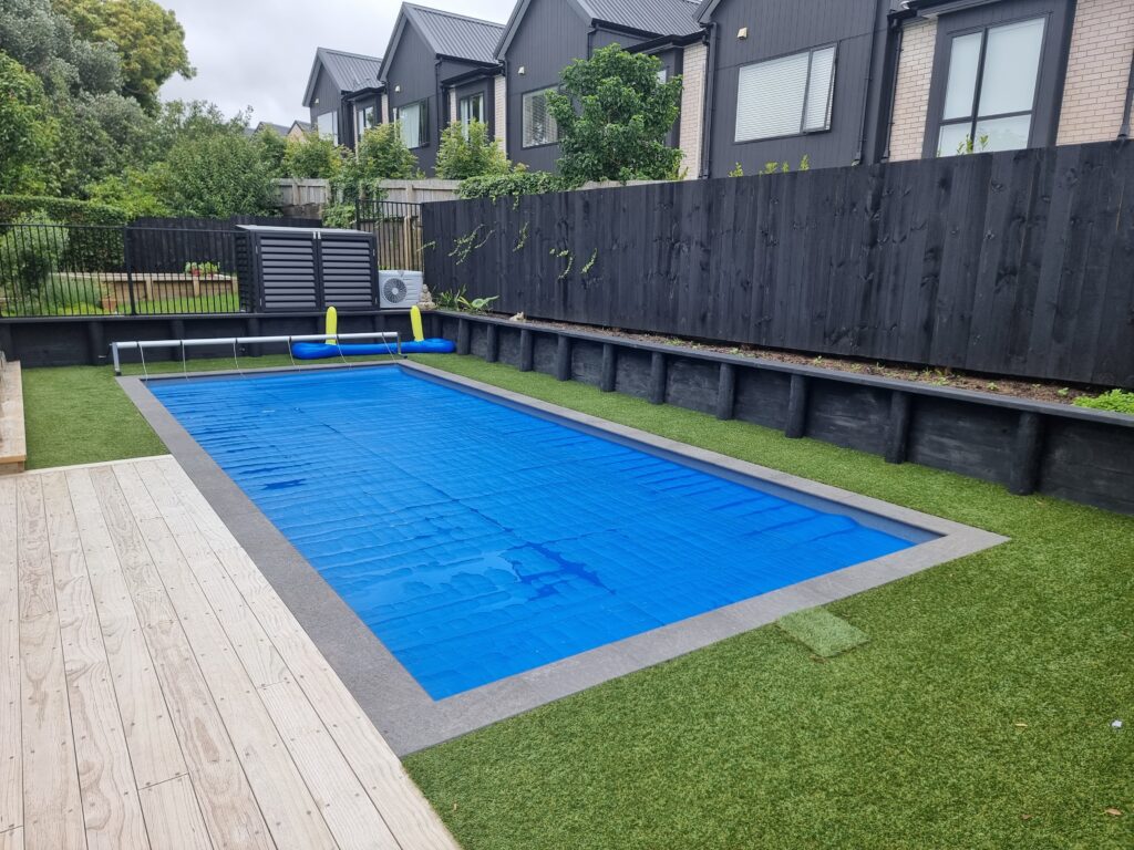 Dark stone pool coping edging an Auckland lap pool